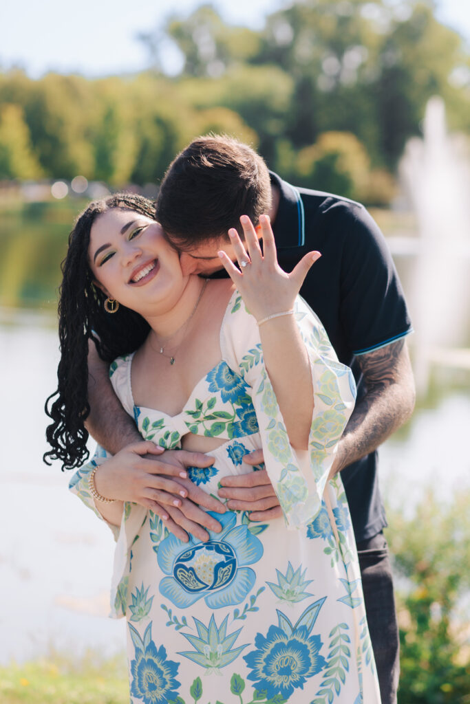 Couple hugging each other while showing ring in Andrew Haydon Park