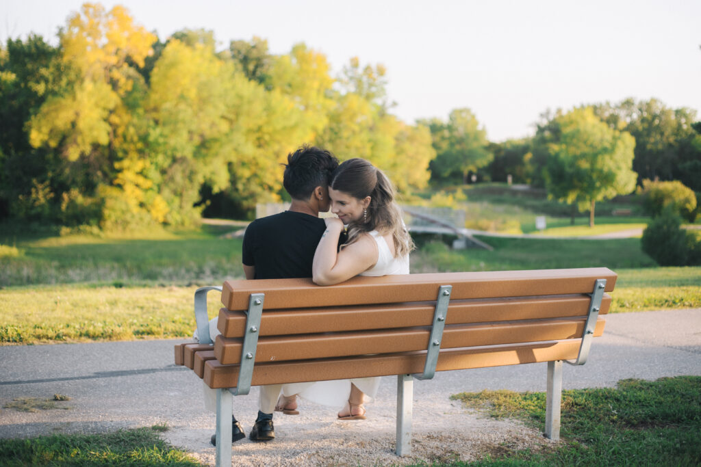 Couple sitting on bench at Kings Park in Winnipeg
