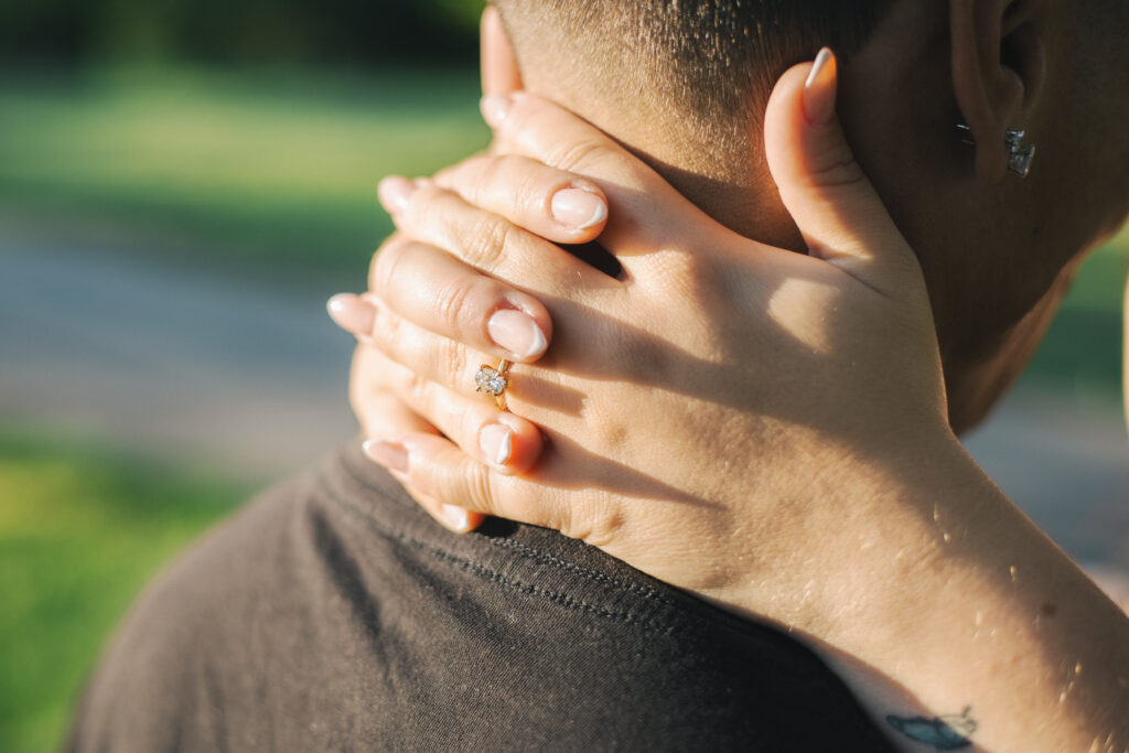 Couple showing ring behind the neck of partner