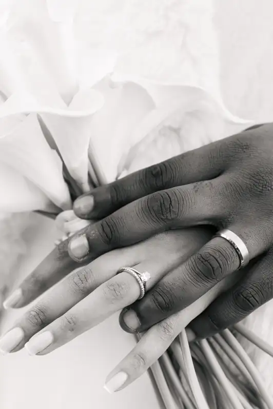 Close-up of a couple holding hands in Ottawa, highlighting their wedding rings with a focus on sparkling detail and connection.