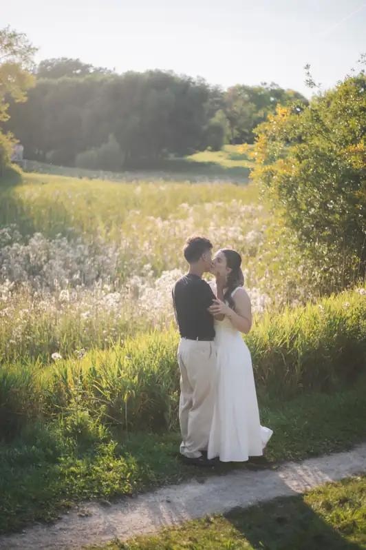 Couple sharing a romantic moment standing in a vibrant Ottawa wildflower field during the peak summer bloom