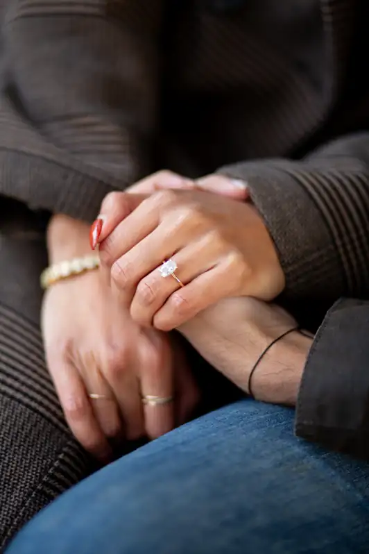 A close-up shot of a couple’s hands intertwined, focusing on the bride's engagement ring with a soft-focus background of an Ottawa park.