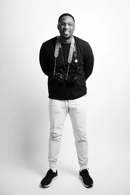 A professional photoof Ottawa-based photographer Herby Cadet, smiling warmly at the camera, wearing a clean and modern outfit.